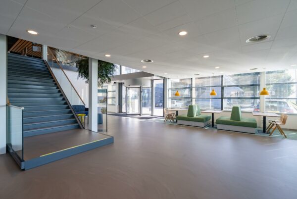 Moderne entreehal van Rivium Promenade met trap, zitgedeelte en grote raampartijen.